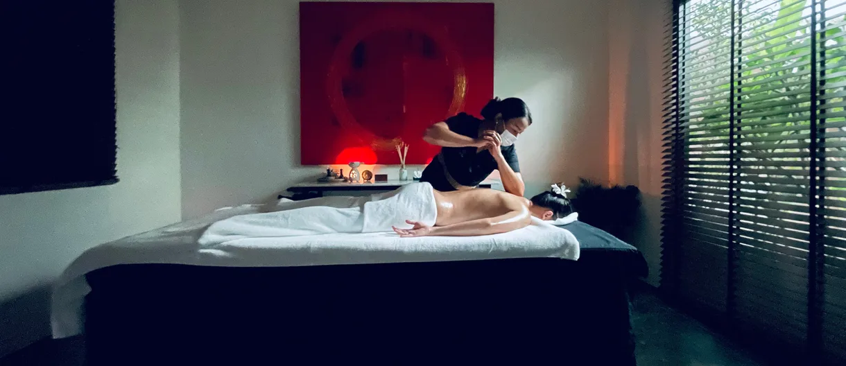 Loft Thai therapist applying focused pressure in a private Bangkok treatment room