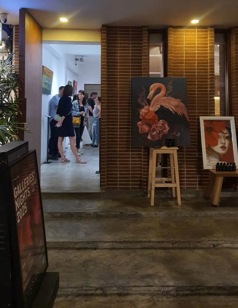Visitors gathering inside ARTIS24 during Galleries’ Night Bangkok 2025 with paintings displayed at the entrance