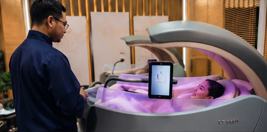An OSIM specialist demonstrating the personalised uDream.AI chair interface